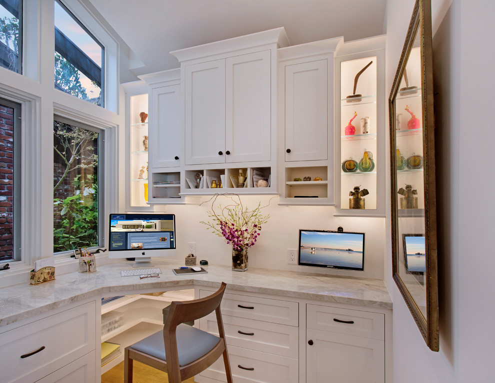 This is an example of a mid-sized arts and crafts home office in Los Angeles with white walls, light hardwood floors, no fireplace, a built-in desk and beige floor.