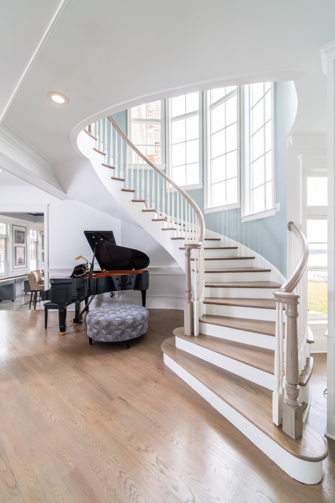 Photo of a beach style wood curved staircase in Baltimore with painted wood risers and wood railing.