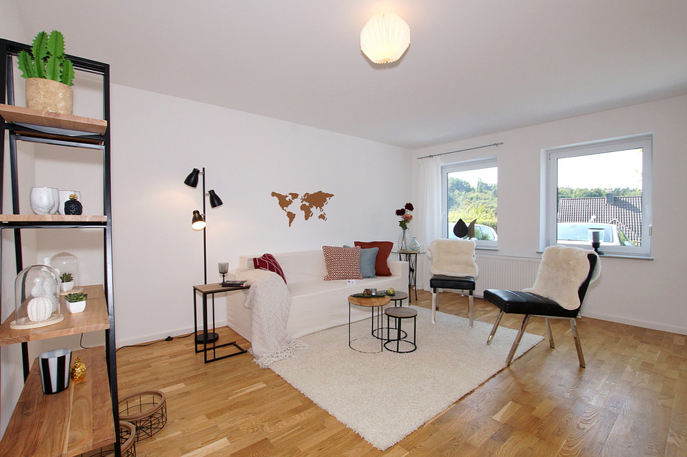 Small scandinavian family room in Cologne with white walls and medium hardwood floors.