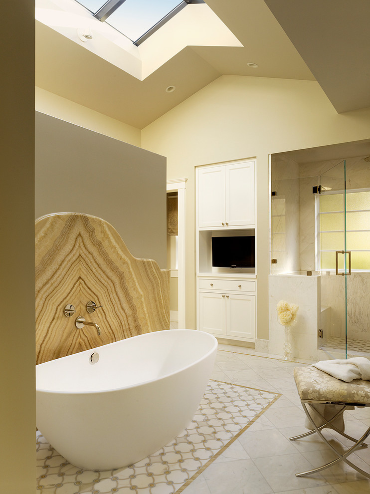 This is an example of a transitional master bathroom in San Francisco with shaker cabinets, white cabinets, a freestanding tub, an alcove shower, beige walls and a hinged shower door.