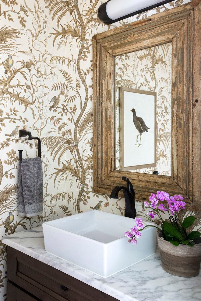 Inspiration for a small transitional powder room in Other with recessed-panel cabinets, dark wood cabinets, multi-coloured walls, a vessel sink and marble benchtops.