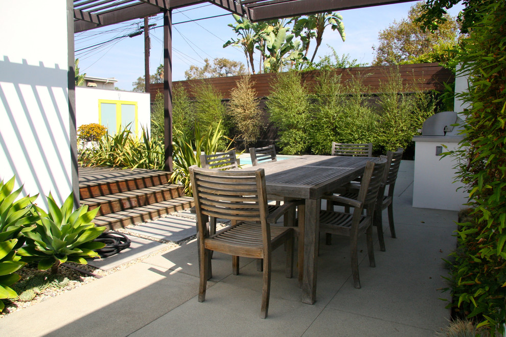 This is an example of a mid-sized contemporary backyard full sun garden in Los Angeles with concrete pavers.