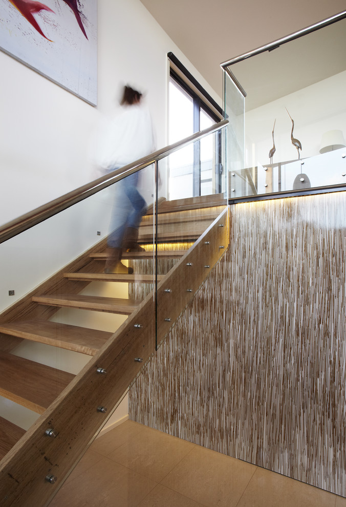 Photo of a beach style wood straight staircase in Melbourne with open risers and glass railing.