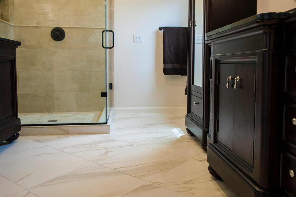 Inspiration for a traditional master bathroom in Nashville with furniture-like cabinets, dark wood cabinets, granite benchtops, multi-coloured tile, stone tile, an undermount sink, beige walls and porcelain floors.