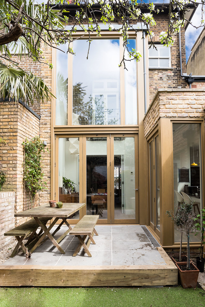 Photo of a contemporary backyard patio in London with concrete pavers and no cover.