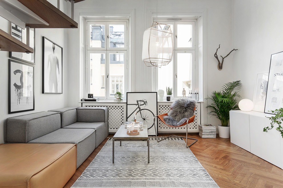 Photo of a mid-sized scandinavian formal open concept living room in Stockholm with white walls, medium hardwood floors and no fireplace.