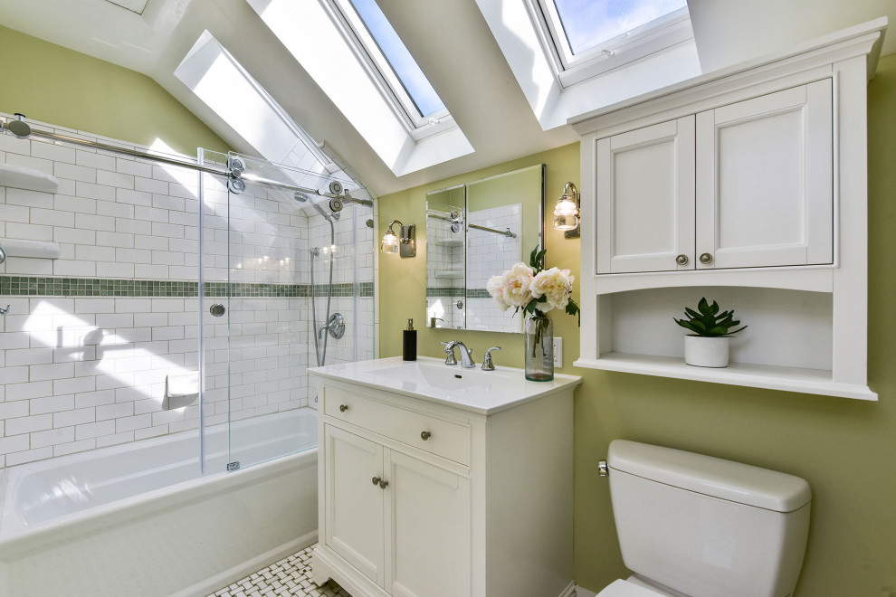 Transitional bathroom in San Francisco with recessed-panel cabinets, white cabinets, an alcove tub, a shower/bathtub combo, white tile, subway tile, green walls, mosaic tile floors, an integrated sink, multi-coloured floor, a sliding shower screen, white benchtops, a single vanity, a freestanding vanity and vaulted.