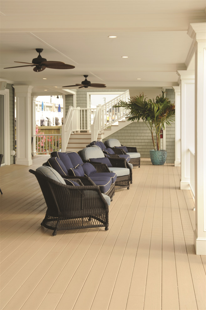 This is an example of a large beach style backyard deck in New York with an awning.