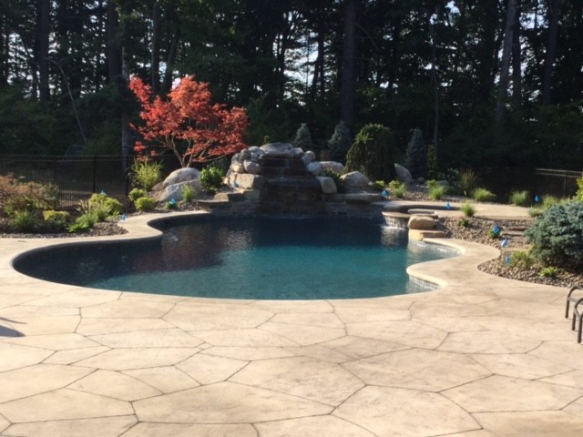 Inspiration for a large transitional backyard stone and custom-shaped pool remodel in Boston