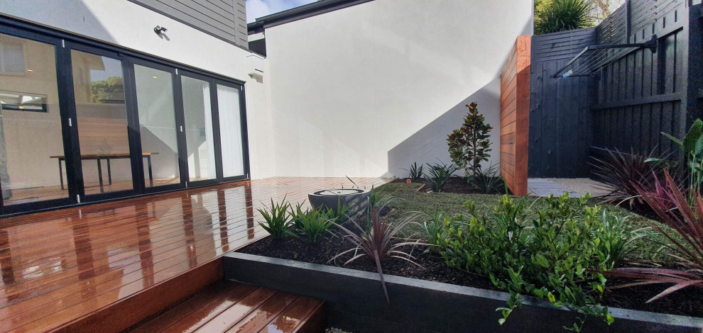 This is an example of a small contemporary backyard and ground level deck in Melbourne with with privacy feature.