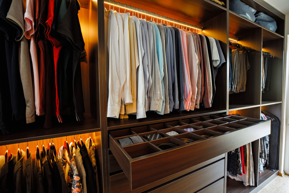 This is an example of an expansive modern walk-in wardrobe in Stuttgart with open cabinets, bamboo floors and brown floor.