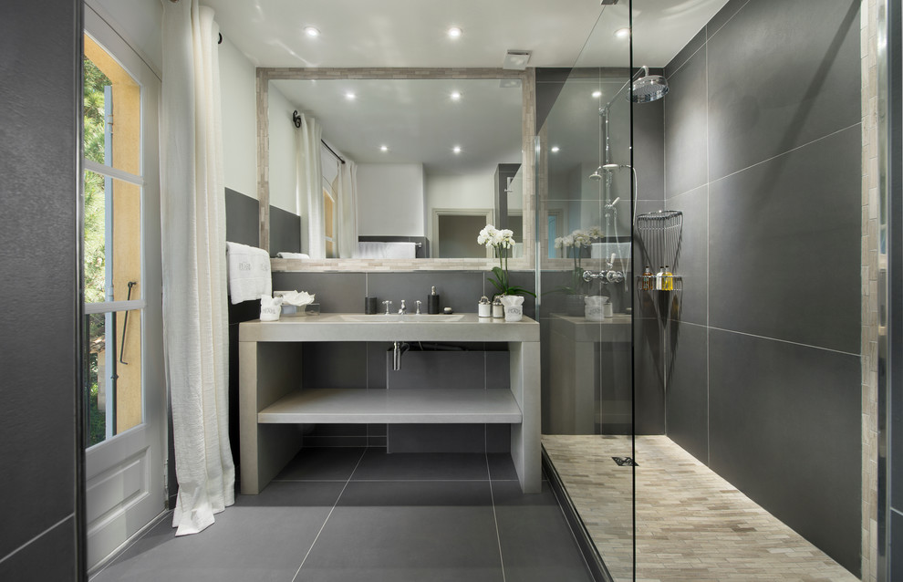 Inspiration for a transitional bathroom in London with an integrated sink, a corner shower and gray tile.
