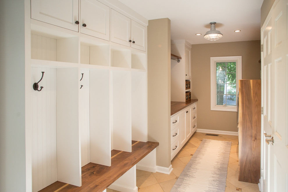 Design ideas for a large transitional galley utility room in Philadelphia with shaker cabinets, white cabinets, wood benchtops, beige walls, ceramic floors and a side-by-side washer and dryer.