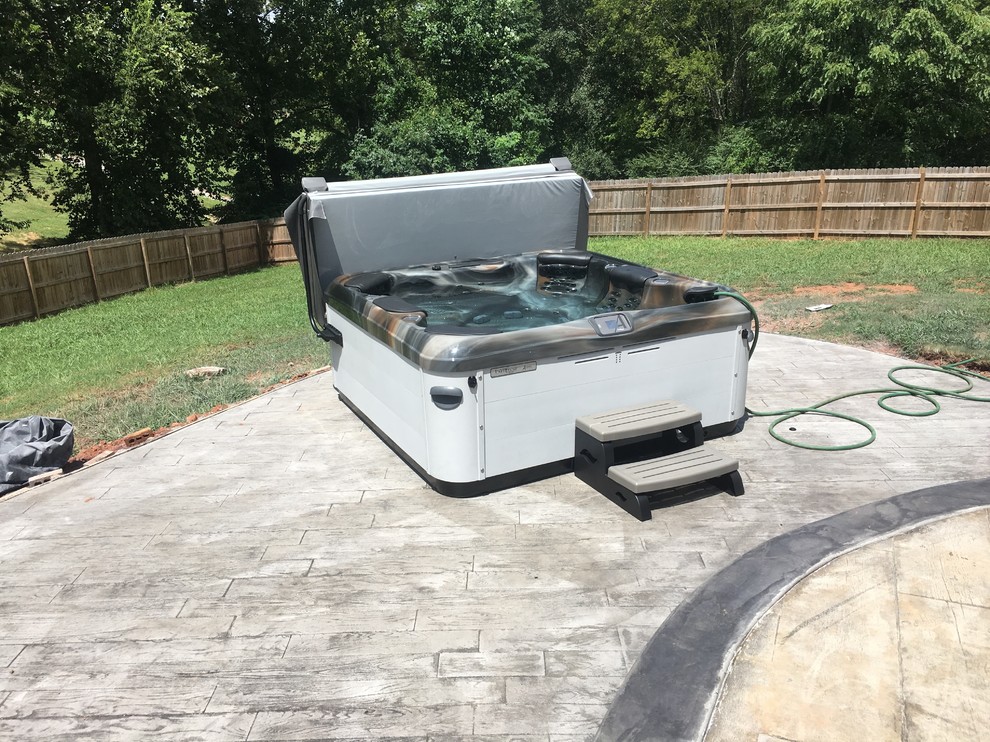 Mid-sized transitional backyard stamped concrete and rectangular hot tub photo