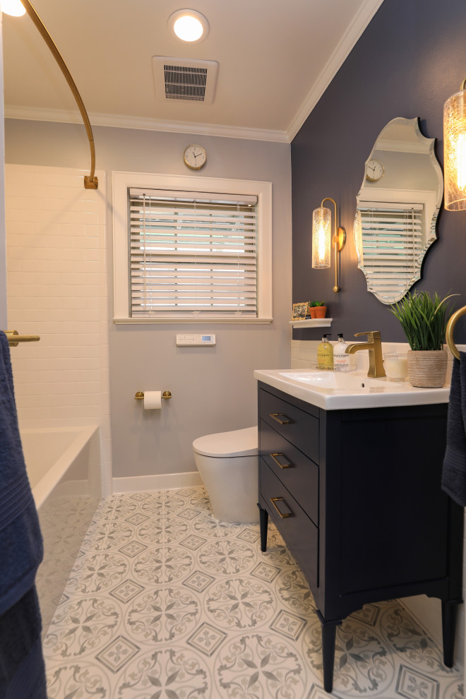 This is an example of a small transitional bathroom in Houston with flat-panel cabinets, blue cabinets, a drop-in tub, a shower/bathtub combo, a one-piece toilet, white tile, porcelain tile, blue walls, ceramic floors, an integrated sink, solid surface benchtops, multi-coloured floor, a shower curtain and white benchtops.