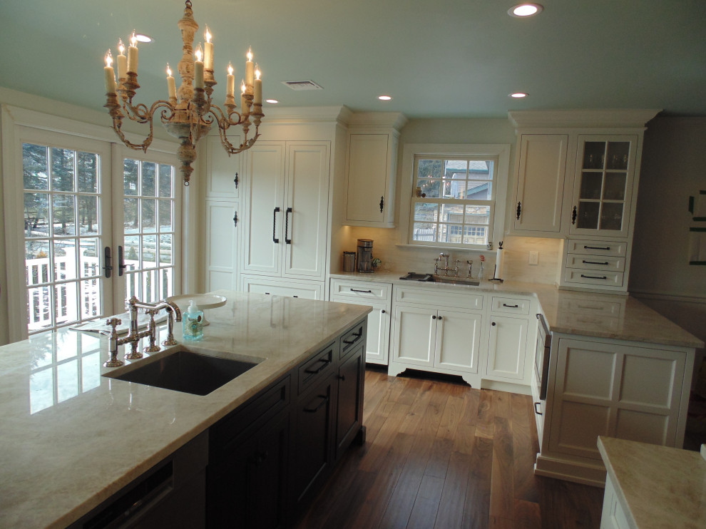 Large transitional u-shaped medium tone wood floor and brown floor eat-in kitchen photo with an undermount sink, recessed-panel cabinets, white cabinets, quartzite countertops, beige backsplash, subway tile backsplash, stainless steel appliances, an island and beige countertops