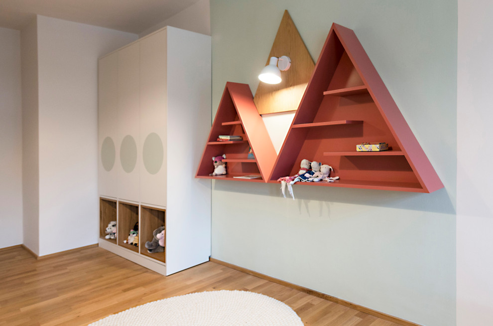 Idée de décoration pour une grande chambre de fille de 4 à 10 ans design avec un mur vert, un sol en bois brun et un sol marron.