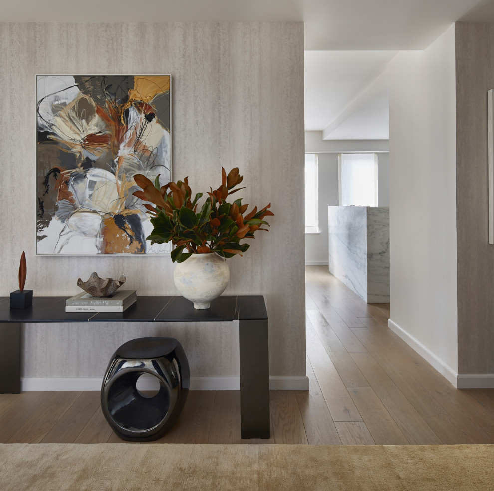 This is an example of a mid-sized contemporary foyer in New York with light hardwood floors, wallpaper and metallic walls.