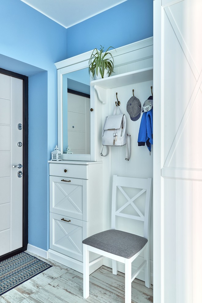 Photo of a beach style mudroom in Other with blue walls, a single front door and a white front door.