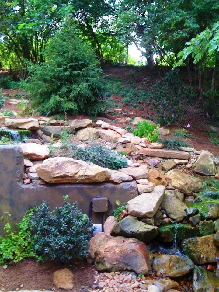 This is an example of a mid-sized transitional full sun backyard stone landscaping in Cincinnati for spring.
