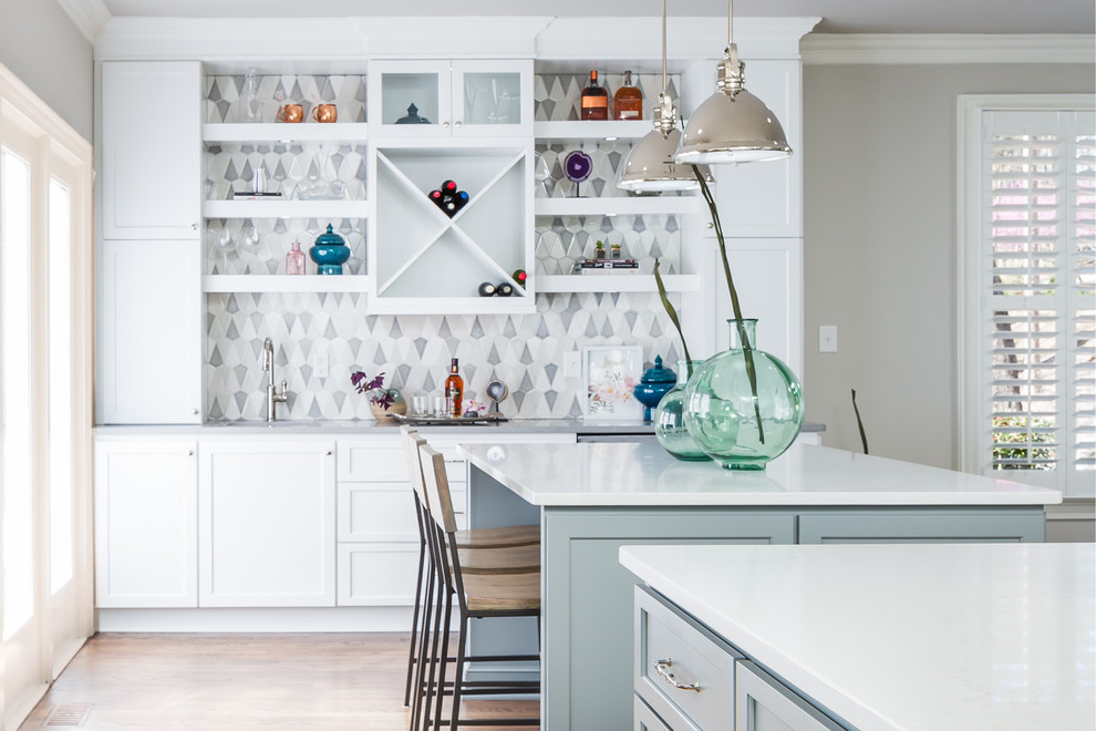 Open concept kitchen - huge transitional galley medium tone wood floor open concept kitchen idea in Raleigh with a farmhouse sink, flat-panel cabinets, white cabinets, quartz countertops, gray backsplash, ceramic backsplash, stainless steel appliances and two islands