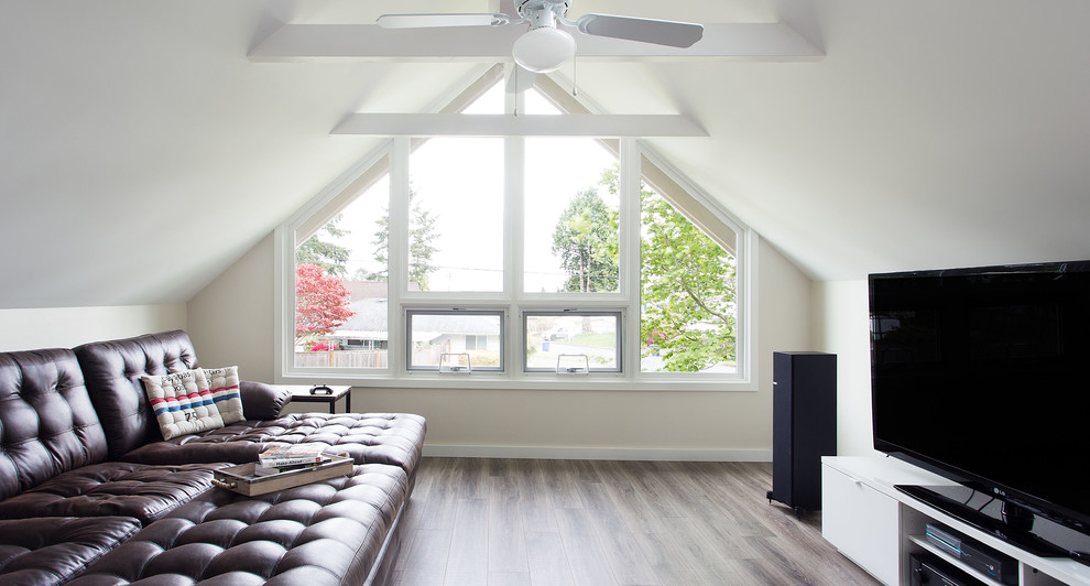Kleiner Klassischer Hobbyraum ohne Kamin, im Loft-Stil mit beiger Wandfarbe, dunklem Holzboden, freistehendem TV und braunem Boden in Seattle