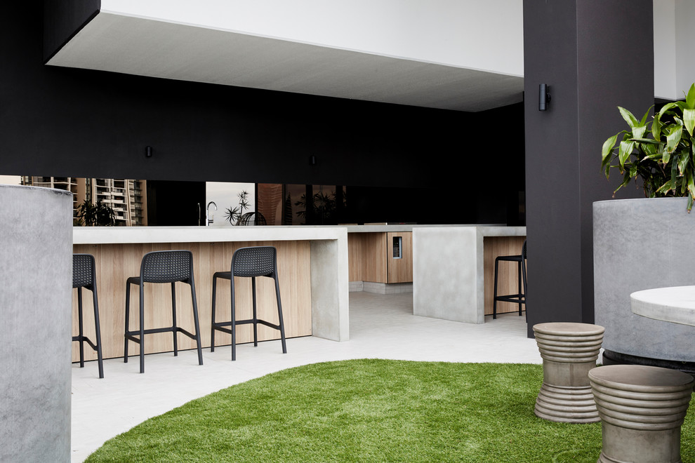 Industrial kitchen in Gold Coast - Tweed with light wood cabinets, concrete benchtops, mirror splashback and with island.