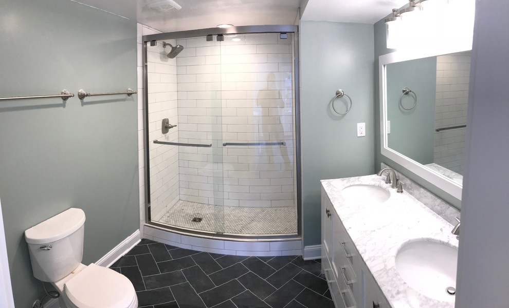 Photo of a mid-sized contemporary bathroom in Other with shaker cabinets, white cabinets, an alcove shower, a one-piece toilet, white tile, subway tile, black walls, slate floors, an undermount sink, engineered quartz benchtops, black floor and a sliding shower screen.