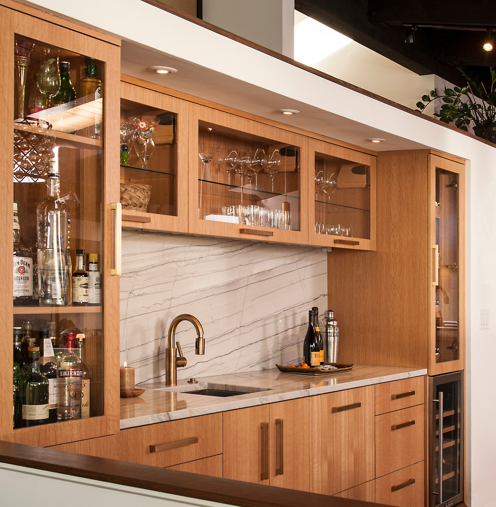 Inspiration for a mid-sized contemporary single-wall wet bar in Seattle with an undermount sink, flat-panel cabinets, light wood cabinets, wood benchtops, grey splashback, stone slab splashback, porcelain floors, grey floor and grey benchtop.