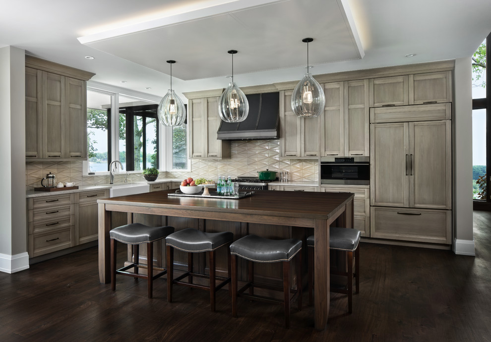 Design ideas for a transitional l-shaped kitchen in Detroit with a farmhouse sink, recessed-panel cabinets, medium wood cabinets, wood benchtops, beige splashback, panelled appliances, dark hardwood floors, with island, brown floor and brown benchtop.