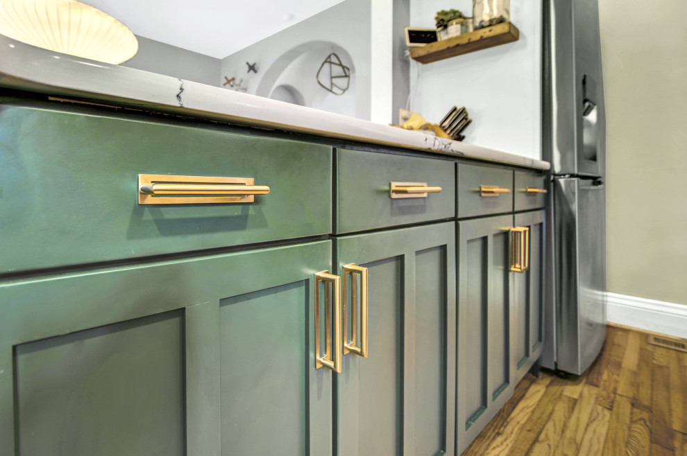This is an example of a small single-wall kitchen/diner in St Louis with green cabinets, metro tiled splashback, stainless steel appliances, a breakfast bar, brown floors, multicoloured worktops and white splashback.