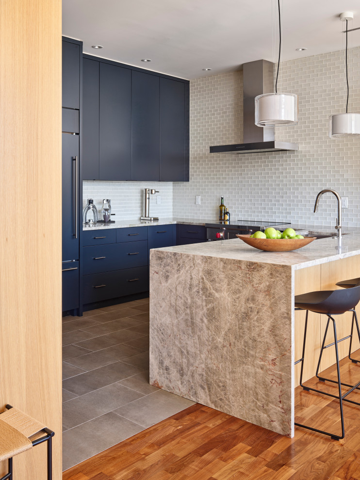 Design ideas for a small contemporary u-shaped eat-in kitchen in Philadelphia with an undermount sink, flat-panel cabinets, blue cabinets, quartzite benchtops, white splashback, glass tile splashback, panelled appliances, porcelain floors, a peninsula, grey floor and grey benchtop.