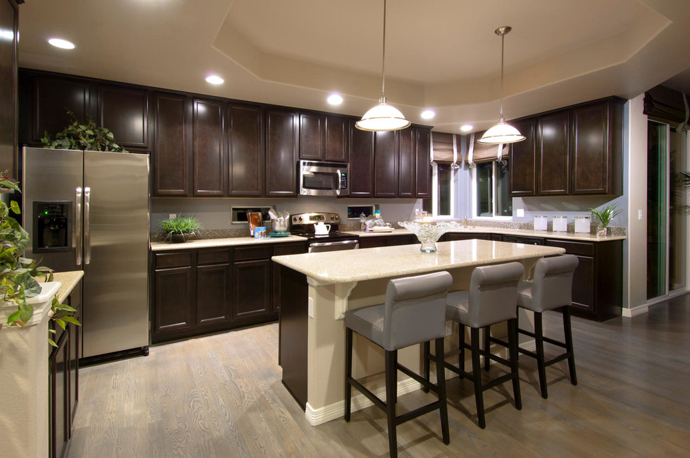 Traditional kitchen in Denver with recessed-panel cabinets, dark wood cabinets and stainless steel appliances.