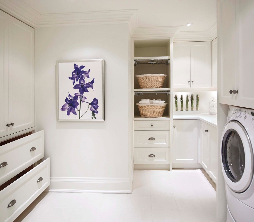Inspiration for a mid-sized traditional u-shaped dedicated laundry room in Toronto with white cabinets, an undermount sink, shaker cabinets, solid surface benchtops, white walls, porcelain floors, a side-by-side washer and dryer and white benchtop.