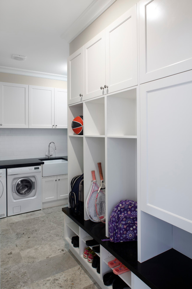 Design ideas for a mid-sized traditional l-shaped utility room in Sydney with a farmhouse sink, shaker cabinets, white cabinets, quartz benchtops, beige walls, porcelain floors and a side-by-side washer and dryer.