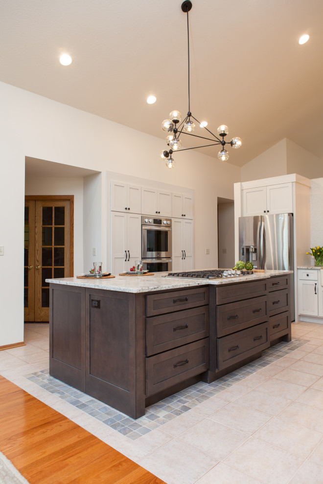 Large transitional galley separate kitchen in Chicago with a farmhouse sink, recessed-panel cabinets, white cabinets, granite benchtops, white splashback, glass tile splashback, stainless steel appliances, porcelain floors, with island, beige floor and multi-coloured benchtop.
