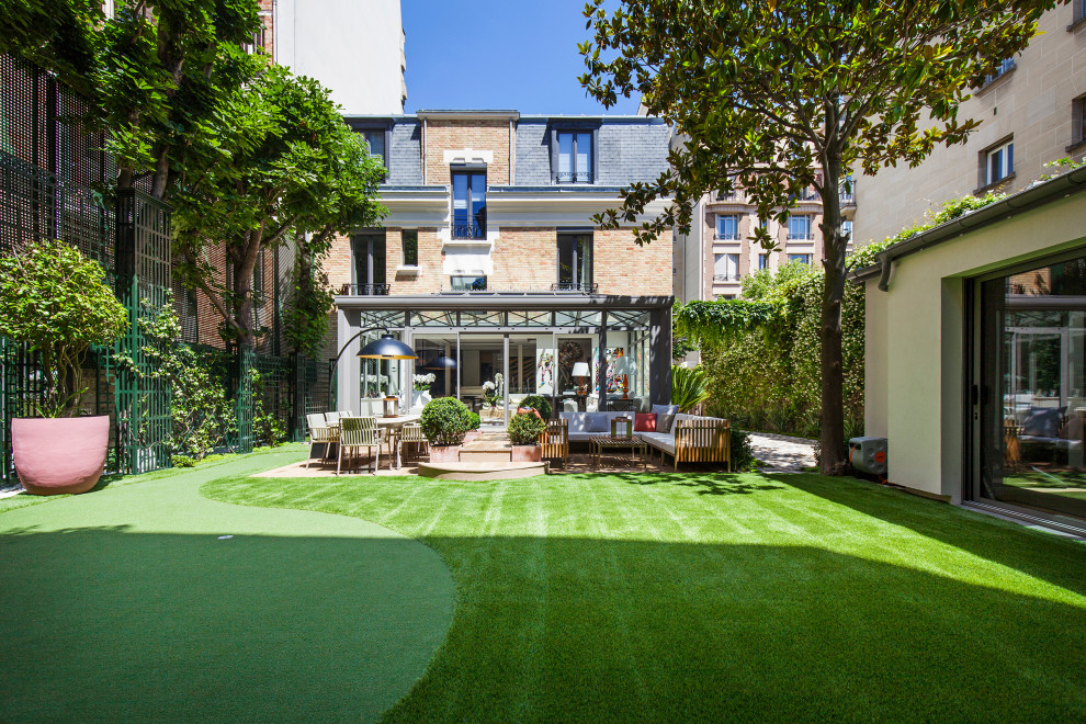 Mittelgroßer, Halbschattiger Moderner Garten hinter dem Haus, im Frühling mit Sichtschutz und Dielen in Paris
