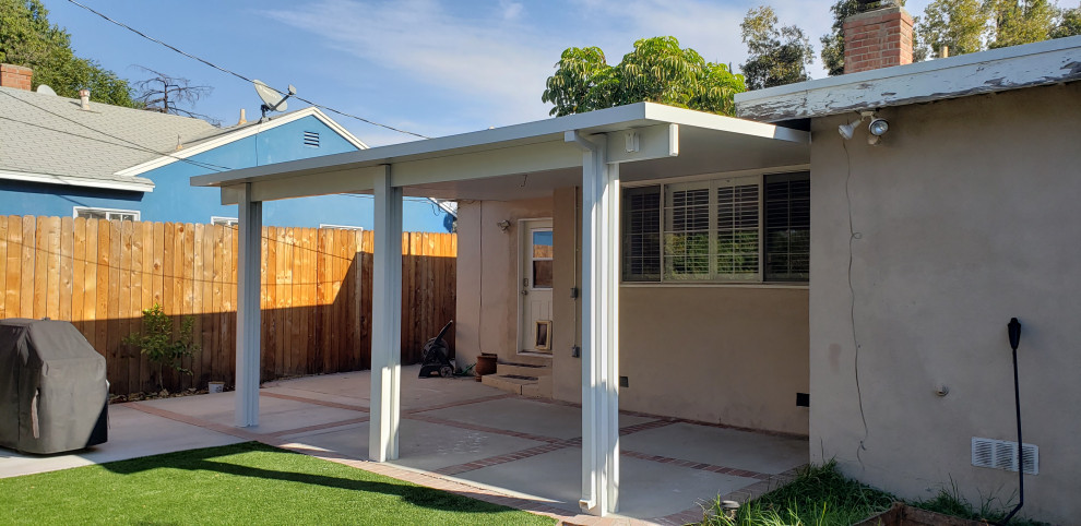 Inspiration for a medium sized modern back patio in Los Angeles with concrete slabs and a roof extension.