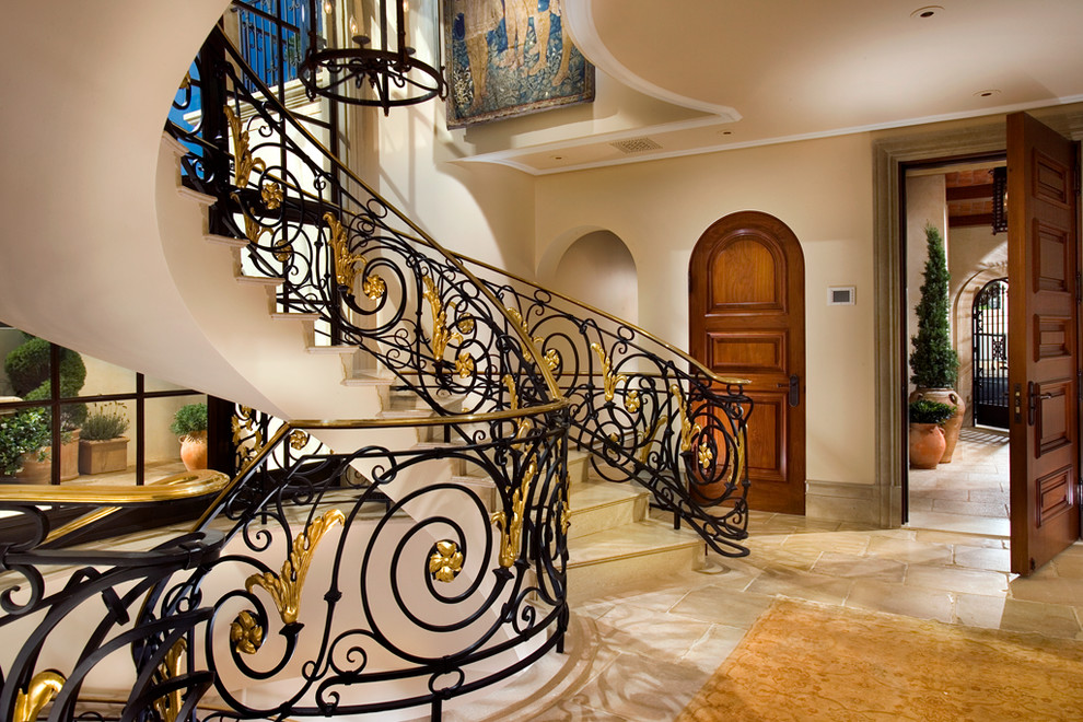 This is an example of a large traditional tile curved staircase in Los Angeles with metal risers.