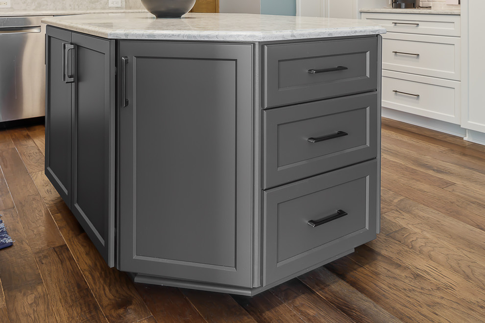 Example of a brown floor eat-in kitchen design with white cabinets, white backsplash, stainless steel appliances, an island and gray countertops