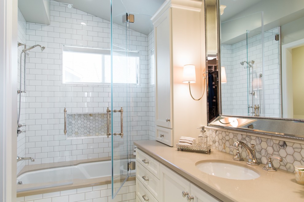 Design ideas for a mid-sized traditional master bathroom in San Francisco with an undermount sink, white cabinets, engineered quartz benchtops, an undermount tub, a shower/bathtub combo, a one-piece toilet, white tile, porcelain tile, grey walls, marble floors and recessed-panel cabinets.