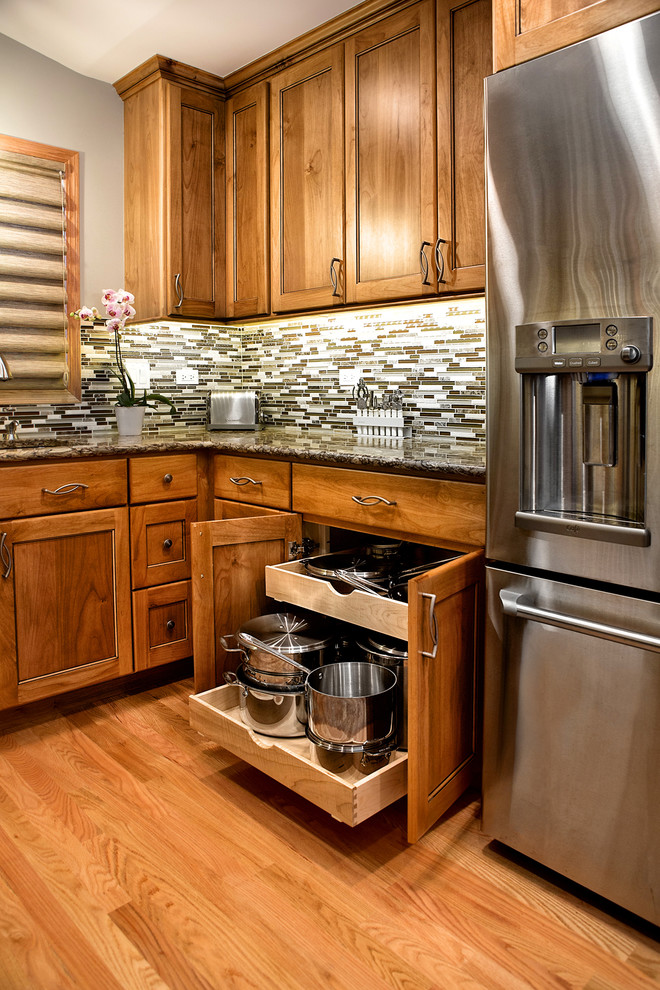 This is an example of a large traditional kitchen pantry in Chicago with an undermount sink, medium wood cabinets, multi-coloured splashback, stainless steel appliances, light hardwood floors and no island.