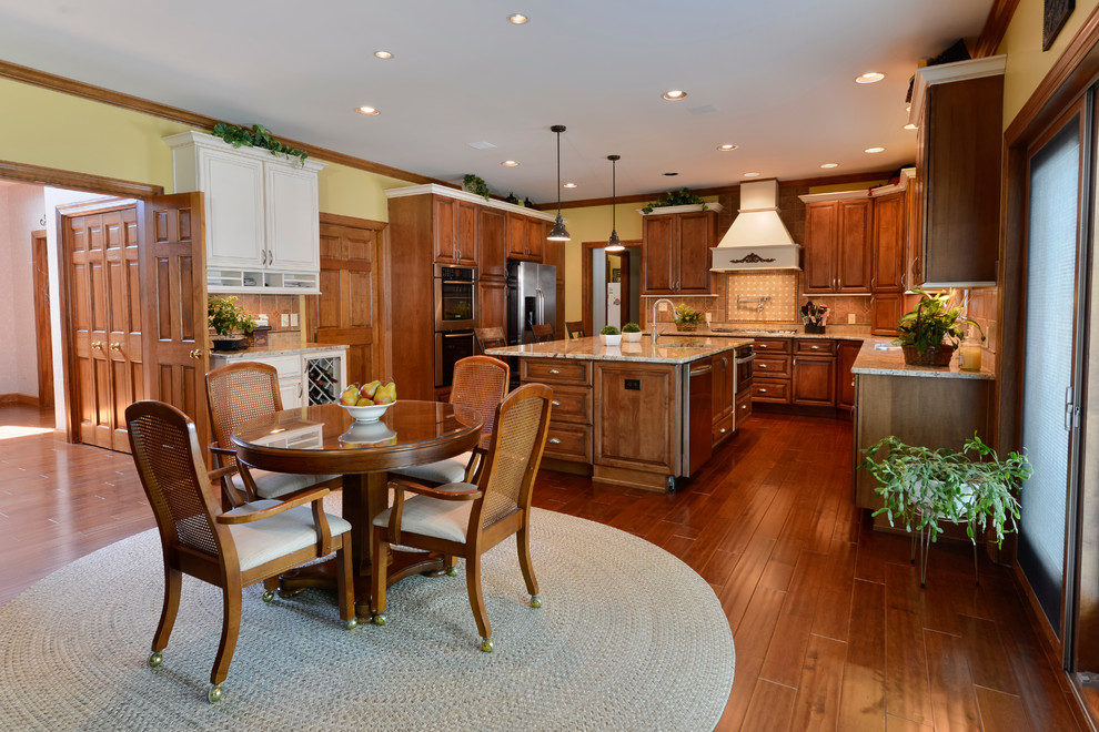 Eat-in kitchen - large transitional u-shaped medium tone wood floor eat-in kitchen idea with beaded inset cabinets, medium tone wood cabinets, granite countertops, beige backsplash, mosaic tile backsplash, stainless steel appliances and an island