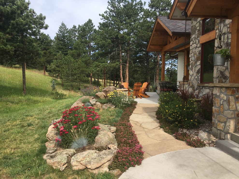Photo of a mid-sized country front yard full sun xeriscape for summer in Denver with a fire feature and natural stone pavers.