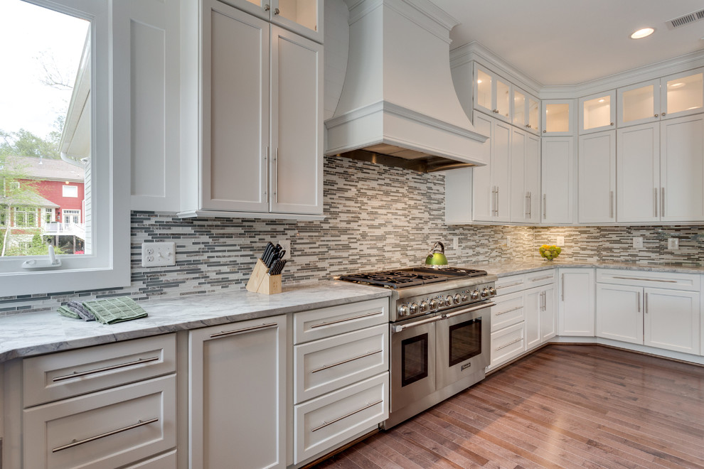 Inspiration for a large transitional u-shaped open plan kitchen in DC Metro with an undermount sink, white cabinets, granite benchtops, glass tile splashback, stainless steel appliances, dark hardwood floors, with island, shaker cabinets and multi-coloured splashback.