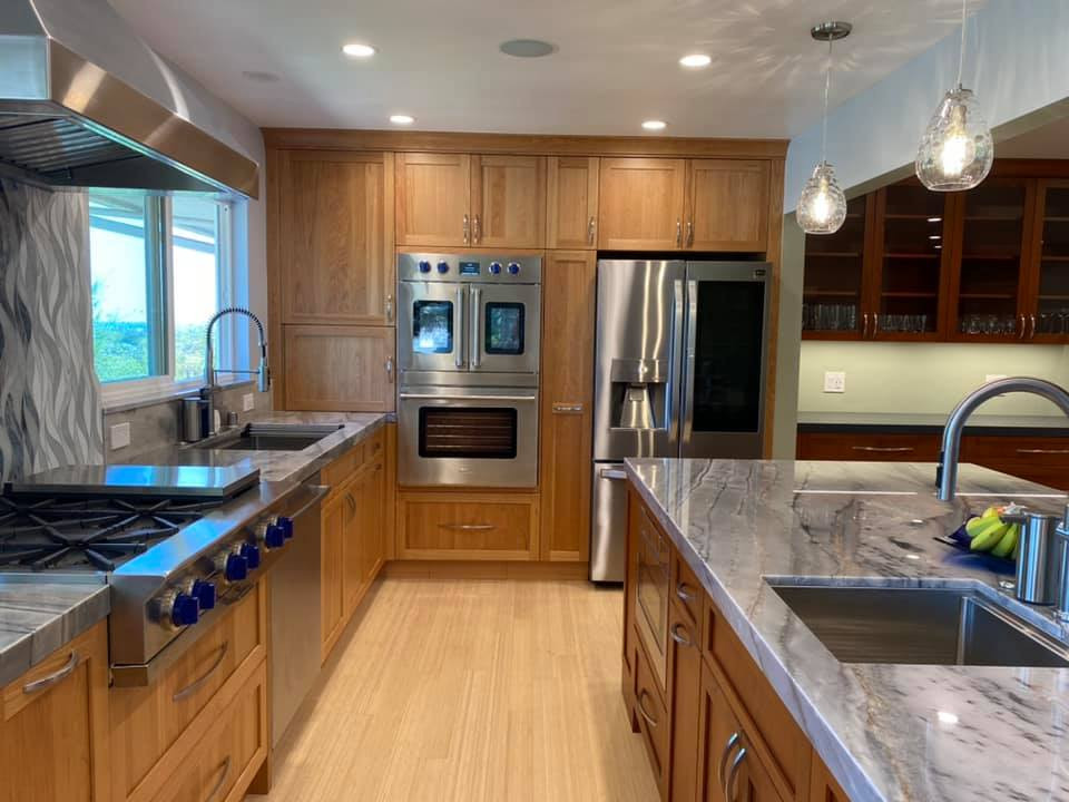 Exempel på ett stort amerikanskt grå grått kök, med en undermonterad diskho, skåp i shakerstil, skåp i mellenmörkt trä, bänkskiva i kvartsit, grått stänkskydd, stänkskydd i glaskakel, rostfria vitvaror, bambugolv, en halv köksö och gult golv