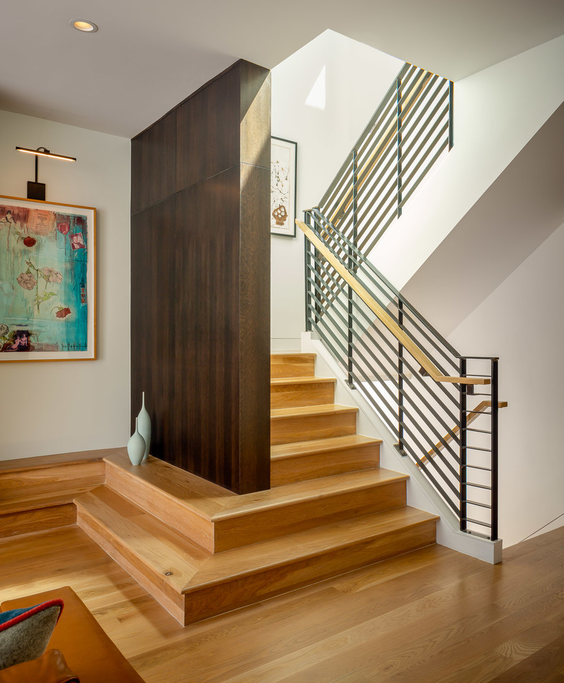 Large midcentury wood u-shaped staircase in San Francisco with wood risers and cable railing.