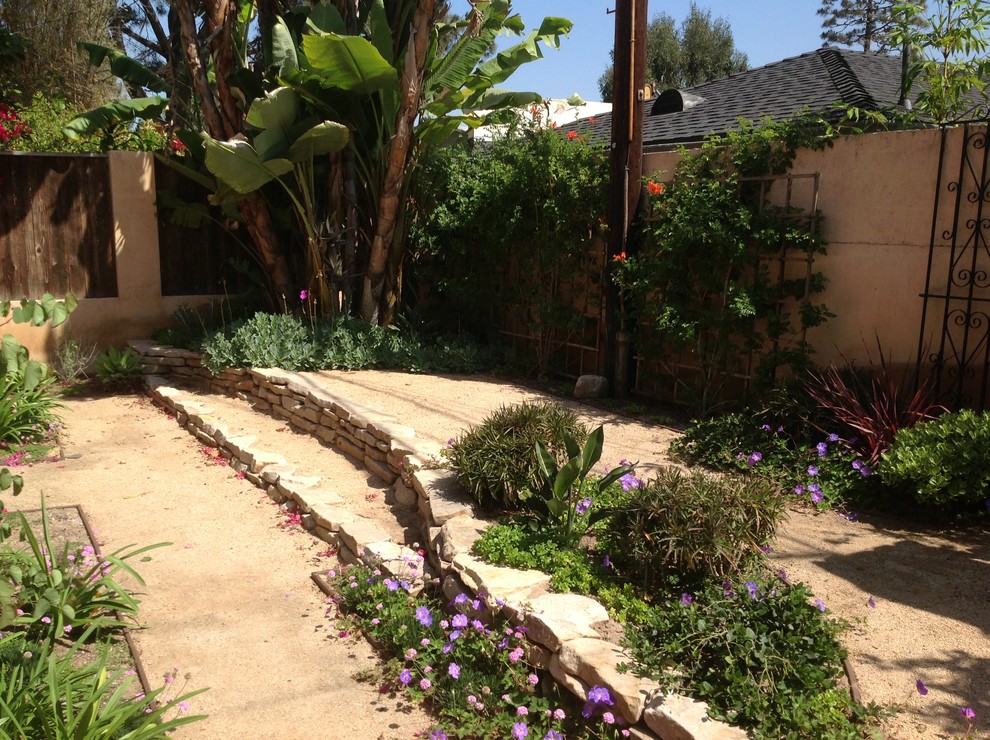 This is an example of a mid-sized traditional backyard xeriscape in Los Angeles with gravel.