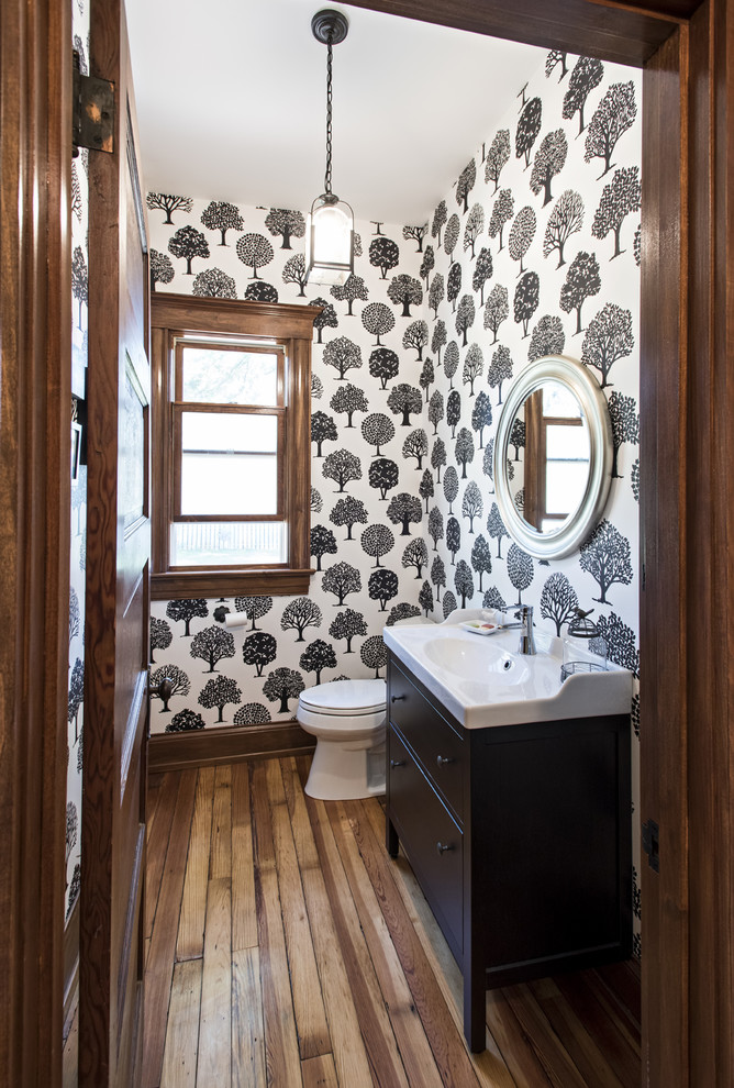 Mid-sized transitional powder room in Louisville with furniture-like cabinets, black cabinets and medium hardwood floors.