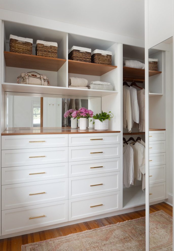 Example of a transitional women's medium tone wood floor closet design in Baltimore with white cabinets